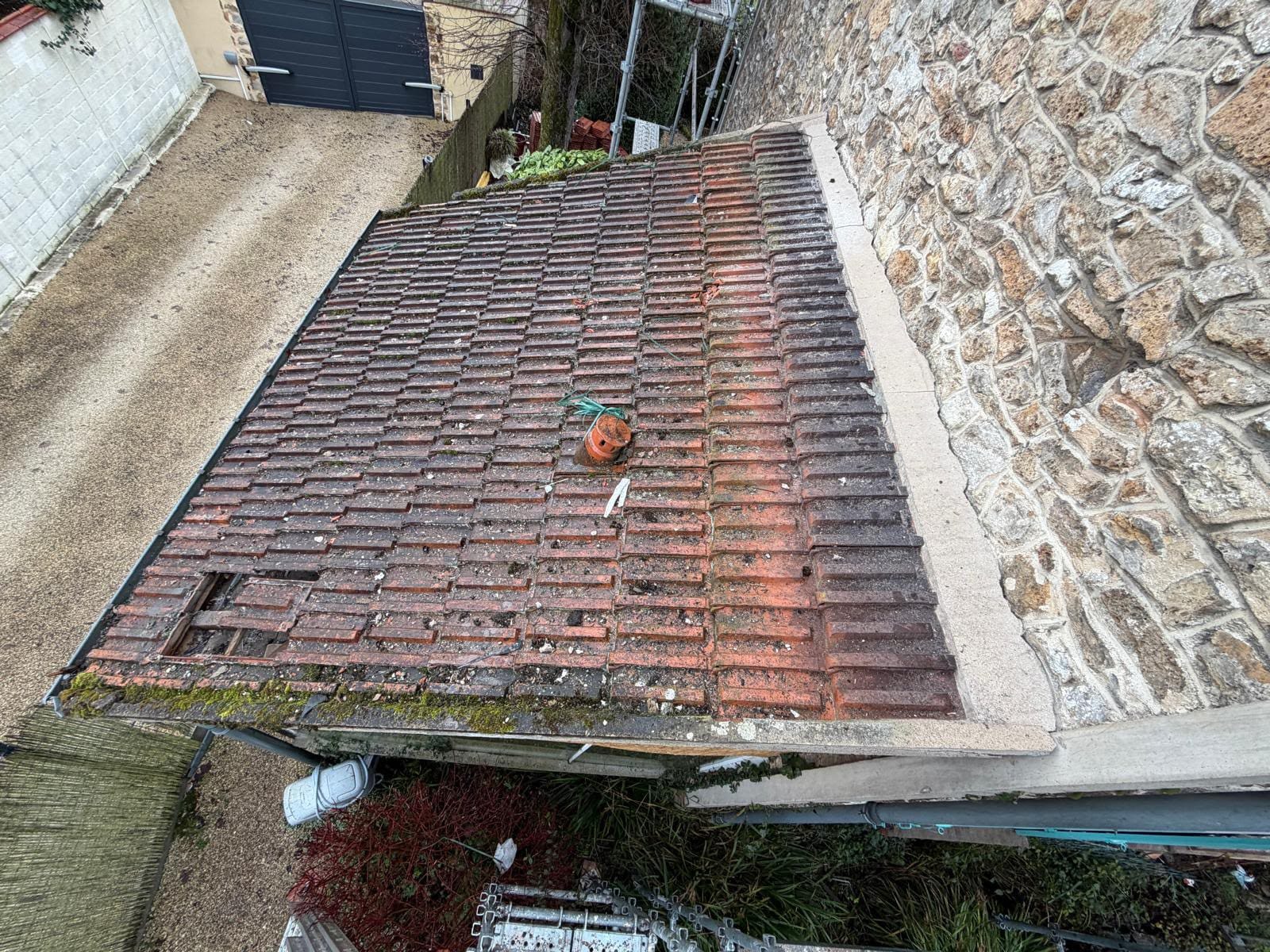 Couverture de garage ancienne avec tuiles cassées, trous et mousse avant rénovation en Essonne