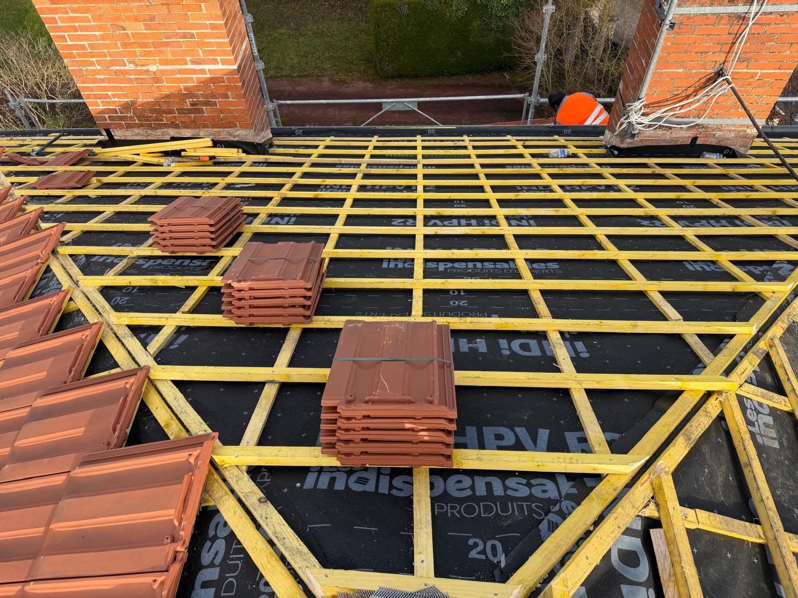 Liteaunage neuf et palettes de tuiles prêtes à poser sur écran de sous-toiture, chantier VJ Couverture