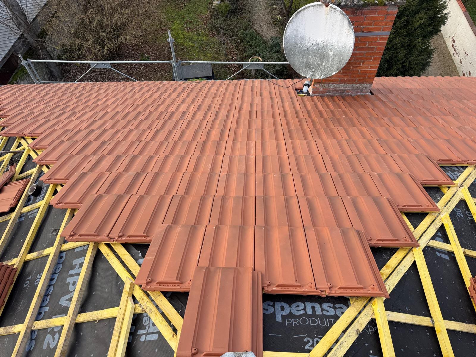 Pose d'un closoir ventilé souple agrafé sur la lisse de faîtage d'une toiture en tuiles béton